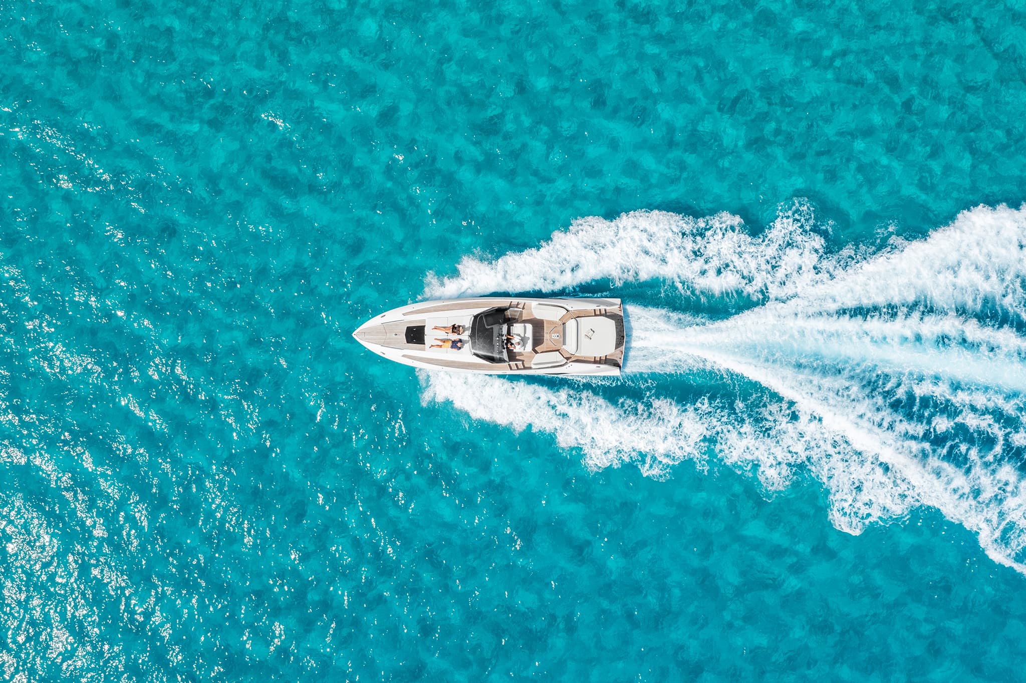 Aerial view of a yacht at anchor in turquoise Ibiza water